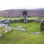 Stone hut circle with author